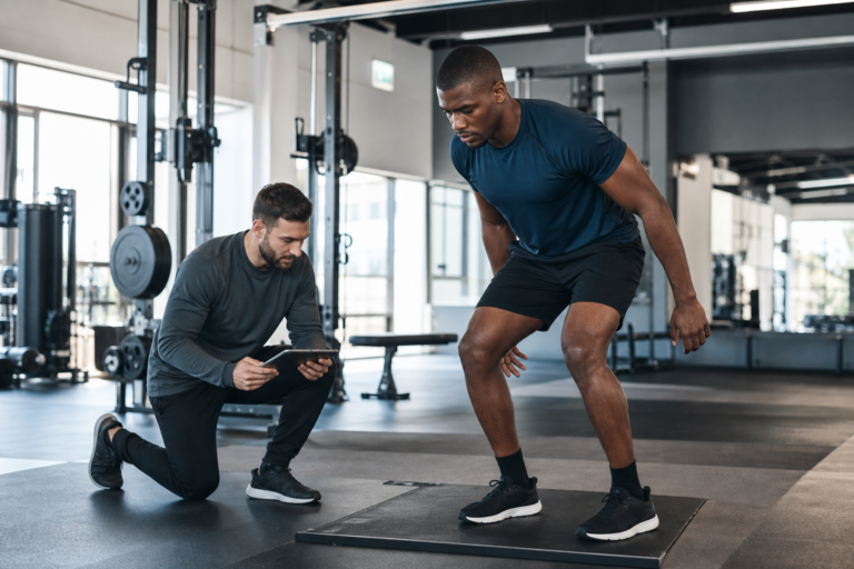 Athlete and coach reviewing strength testing in a performance gym